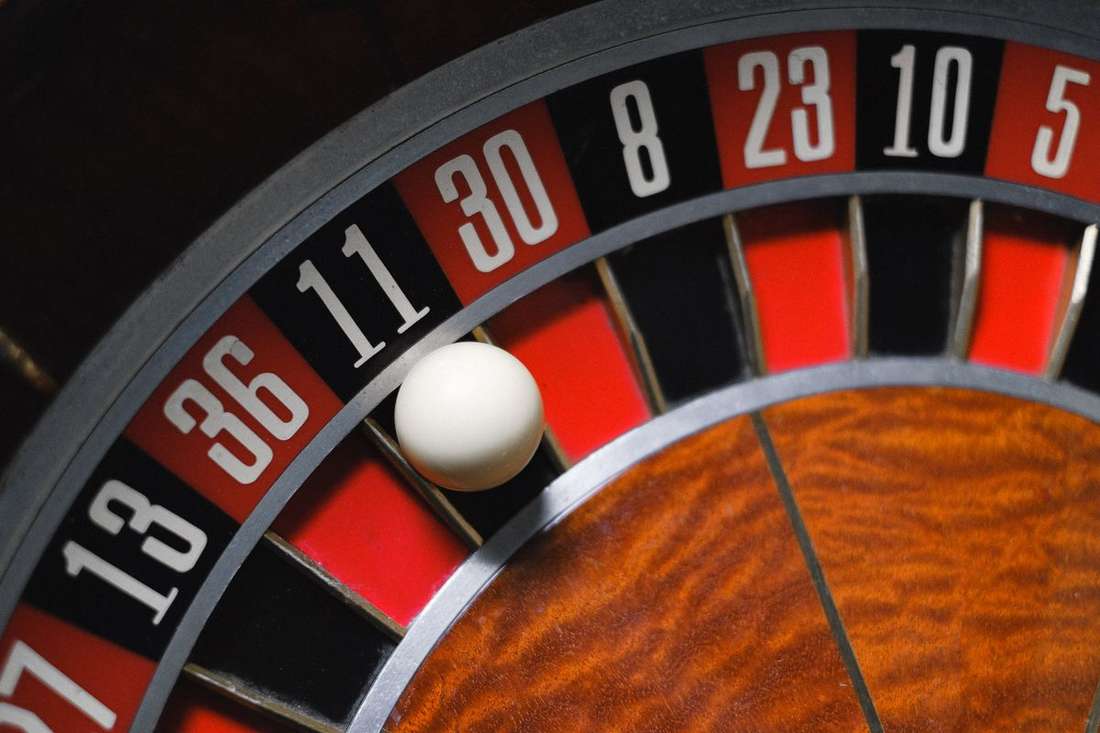 Roda roulette berwarna merah hitam di atas meja kasino